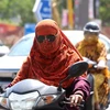 Người dân di chuyển trên đường phố dưới trời nắng nóng tại Bhopal, bang Madhya Pradesh, Ấn Độ, ngày 6/7/2023. (Ảnh: THX/TTXVN)