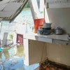 Phần nhà sau của một hộ dân bị sạt lở nhấn chìm xuống sông Bình Thủy. (Ảnh: Thanh Liêm/TTXVN)