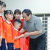 Thủ tướng Phạm Minh Chính tặng quà cho trẻ em khuyết tật tại Trung tâm Nuôi dưỡng trẻ khuyết tật Hà Nội. (Ảnh: Dương Giang/TTXVN)