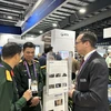 Thiếu tướng Lê Quang Tuyến, Phó Chủ nhiệm Tổng cục Công nghiệp Quốc phòng, trao đổi thông tin với một số doanh nghiệp, tập đoàn có sản phẩm trưng bày tại triển lãm. (Ảnh: Trung Dũng/TTXVN)