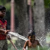 Trẻ em chơi đùa với nước trong ngày nắng nóng tại New Delhi, Ấn Độ, ngày 31/5. (Ảnh: AFP/TTXVN)