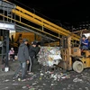 Một số công nhân của nhà máy dọn dẹp phế phẩm phụ của rác thải sau khi dây chuyền xử lý rác ngừng hoạt động. (Ảnh: Nguyễn Dũng/TTXVN)
