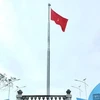 Cán bộ và lực lượng vũ trang bên cột cờ Tổ quốc vừa khánh thành trên đảo Thanh Lân, Cô Tô, Quảng Ninh. (Ảnh: TTXVN phát)