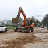 Thành phố Hà Giang huy động các lực lượng và phương tiện dọn dẹp tuyến đường bị ngập sâu. (Ảnh: TTXVN phát)