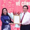 Trưởng Ban Tuyên giáo Trung ương Nguyễn Trọng Nghĩa trao quyết định cho bà Đinh Thị Mai. (Ảnh: Phương Hoa/TTXVN)