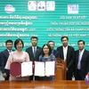 Tổng Giám đốc TTXVN Vũ Việt Trang (bên trái) và Tổng Giám đốc AKP Sokmom Nimul trao đổi thỏa thuận hợp tác nghiệp vụ giai đoạn mới vừa ký kết. (Ảnh: Hoàng Minh/TTXVN)