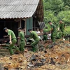 Công an huyện Na Hang (Tuyên Quang) giúp đỡ người dân thôn Khau Phiêng khắc phục hậu quả do mưa lũ. (Ảnh: Nam Sương/TTXVN)