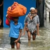 Người dân sơ tán khỏi vùng ngập lụt tại Feni, Chittagong, Bangladesh, ngày 23/8. (Ảnh: Getty Images/TTXVN)