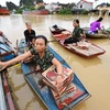 Người dân đến điểm nhận hỗ trợ mỳ tôm, nước uống, bánh mỳ, (Ảnh: Minh Đức/TTXVN)