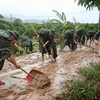 Cán bộ, chiến sĩ Sư đoàn 325 dọn dẹp sình lầy tại thôn Khả Lã, xã Tân Lập, Lục Ngạn. Ảnh: Danh Lam -TTXVN