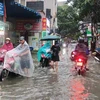 [Photo] Người dân Thủ đô bì bõm lội mưa trong giờ tan tầm