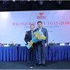 Tân Chủ tịch Liên đoàn Quyền anh Việt Nam Lưu Tú Bảo (phải) trao hoa cho Chủ tịch tiền nhiệm Trần Minh Tiến. (Ảnh: PV/Vietnam+)