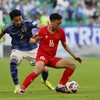 Thái Sơn (số 16) và các đồng đội đã có một trận đấu xuất sắc và chỉ chịu thua với cách biệt hai bàn trước Đội tuyển Nhật Bản. (Ảnh: AFP/TTXVN)