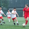 Tuyển thủ Bóng đá Nữ Thái Thị Thảo (áo đỏ) trong trận giao hữu với các bạn nhỏ thuộc Làng trẻ em SOS. (Ảnh: Việt Anh/Vietnam+)