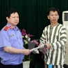 Chánh văn phòng Viện Kiểm sát Nhân dân Tối cao Nguyễn Việt Hùng trao quyết định tạm đình chỉ thi hành án đối với ông Nguyễn Thanh Chấn. (Ảnh: Doãn Tấn/TTXVN) 