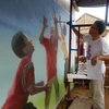 Họa sỹ người Hàn Quốc thể hiện bích họa (Ảnh: UN-Habitat). 