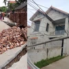 Hình ảnh con đường bị sụt sâu xuống 3-4m cùng ngôi nhà bị lún (Ảnh: Nguyễn Kim Tuấn/Vietnam+) 