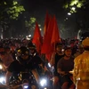 Dòng người hâm mộ mang theo cờ đỏ sao vàng tại phố Tràng Tiền. (Ảnh: Minh Hiếu/Vietnam+) 