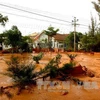 Nước bùn đỏ chảy tràn cả vào nhà các hộ dân. (Ảnh: Nguyễn Thanh/TTXVN)