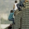 Một nhóm người đang trèo qua hàng rào biên giới để vào Mỹ. Ảnh minh họa. (Nguồn: AP)