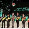 Bộ trưởng Bộ Lao động, Thương binh và Xã hội tặng hoa cho các cá nhân, tập thể có nhiều đóng góp trong việc khắc phục hậu quả bom mìn tại Việt Nam. (Ảnh: Nguyễn Thủy/TTXVN)