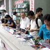 Độc giả chọn mua và đọc sách tại Ngày hội đọc sách năm 2013 tại Thành phố Hồ Chí Minh. (Ảnh: Phương Vy/TTXVN)