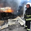 Lính cứu hỏa dập lửa đám cháy khu chợ ở Donetsk sau vụ pháo kích trong xung đột. (Nguồn: AFP/TTXVN)