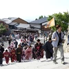 Hướng dẫn viên du lịch cầm cờ dẫn đầu đoàn du khách Trung Quốc mặc kimono thăm đền Kiyomizu-dera ở Kyodo. (Nguồn: Bloomberg)