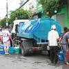 Người dân Rạch Giá phải sử dụng mọi vật dụng hiện có để lấy nước tại các xe bồn cấp nước. (Ảnh: Trường Giang/TTXVN)