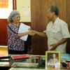 Ông Nguyễn Đại Lượng, Chủ tịch Hội nạn nhân chất độc da cam Sóc Trăng trao cho bà Trần Tố Nga hơn 17.000 chữ ký ủng hộ vụ kiện đòi công lý. (Ảnh: Trung Hiếu/TTXVN)