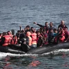 Người di cư tới bờ biển đảo Lesbos sau khi vượt biển Aegean từ Thổ Nhĩ Kỳ ngày 3/9. (AFP/TTXVN)