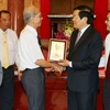 Chủ tịch nước Trương Tấn Sang tặng quà lưu niệm cho cán bộ ngành Tòa án nhân dân qua các thời kỳ. (Ảnh: Nguyễn Khang/TTXVN)