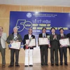 Thứ trưởng Bộ Văn hóa, Thể thao và Du lịch Vương Duy Biên trao kỷ niệm chương vì sự nghiệp Văn học Nghệ thuật cho các nghệ sỹ nhiếp ảnh. (Ảnh: Minh Đức/TTXVN)