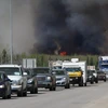 Đoàn xe sơ tán di chuyển tại khu vực đường cao tốc gần đám cháy rừng ở Fort McMurray, Alberta, Canada. (Nguồn: AFP/TTXVN)