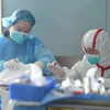 Nhân viên y tế Trung Quốc điều trị cho một bệnh nhân nhiễm virus cúm gia cầm H7N9 tại Trung tâm y tế Vũ Hán ở Vũ Hán, tỉnh Hồ Bắc, miền trung Trung Quốc. (Nguồn: EPA/TTXVN)