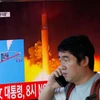 Người dân Hàn Quốc đi qua màn hình đưa tin về việc Triều Tiên phóng tên lửa. (Nguồn: Reuters)