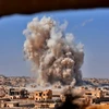 Khói bốc lên sau các cuộc giao tranh giữa binh sĩ quân đội Syria và phiến quân IS ở Bughayliyah, ngoại ô Deir Ezzor ngày 13/9. (Nguồn: AFP/TTXVN)