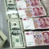 Kiểm đồng USD (trái) tại một ngân hàng ở An Huy, Trung Quốc. (Nguồn: AFP/TTXVN)