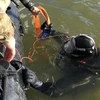Thợ lặn đưa quả bom từ đáy sống lên bờ. (Nguồn: bbc.com)