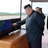 Nhà lãnh đạo Kim Jong-un (trái) thị sát vụ phóng thử tên lửa Hwasong-12 tại một địa điểm bí mật. (Nguồn: AFP/TTXVN)