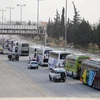  Xe buýt chở phiến quân và người thân rời khỏi thành phố Harasta, Đông Ghouta, Syria ngày 22/3. (Nguồn: THX/TTXVN)