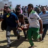 Chuyển người biểu tình Palestine bị thương sau các cuộc đụng độ với binh sỹ Israel tại khu vực biên giới Dải Gaza với Israel ngày 14/5. (Nguồn: THX/TTXVN)