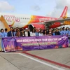 Những hành khách đầu tiên của chuyến bay Cần Thơ-B, Thái Lan chụp ảnh lưu niệm trước khi di chuyển lên máy bay. (Ảnh: Thanh Sang/TTXVN)