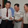 Chủ tịch Hội Khmer-Việt Nam tại Campuchia Châu Văn Chi trao con dấu mới cho các ban và chi hội thành viên. (Ảnh: Nhóm phóng viên TTXVN tại Campuchia)