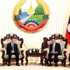 Thủ tướng Thongloun Sisoulith tiếp Bộ trưởng Lê Thành Long. (Ảnh: Phạm Kiên/TTXVN)