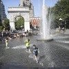 Người dân giải nhiệt tránh nóng tại một đài phun nước ở New York, Mỹ ngày 2/7. (Ảnh: THX/TTXVN)