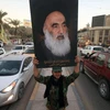 Một thành viên của Hashed al-Shaabi cầm ảnh chân dung của Đại giáo chủ Ali al-Sistani. (Nguồn: AFP)