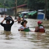 Người dân sơ tán khỏi các khu vực ngập lụt ở Bago ngày 28/7. (Ảnh: THX/TTXVN)