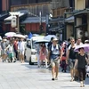 Người dân che ô tránh nắng tại Tokyo, Nhật Bản ngày 23/7. (Ảnh: Kyodo/TTXVN)