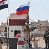 Quốc kỳ Syria và quốc kỳ Nga tại khu vực Abu Duhur, tỉnh Idlib, Syria ngày 25/9. (Ảnh: AFP/TTXVN)